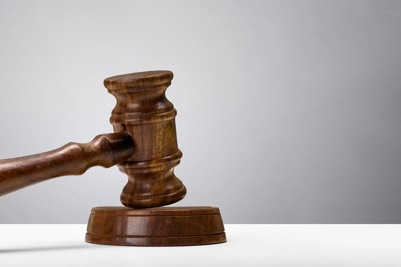 A wooden judge's gavel resting on its block