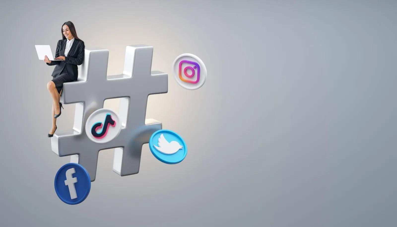 A woman working on a laptop while seated on a giant hashtag symbol surrounded by social media logos